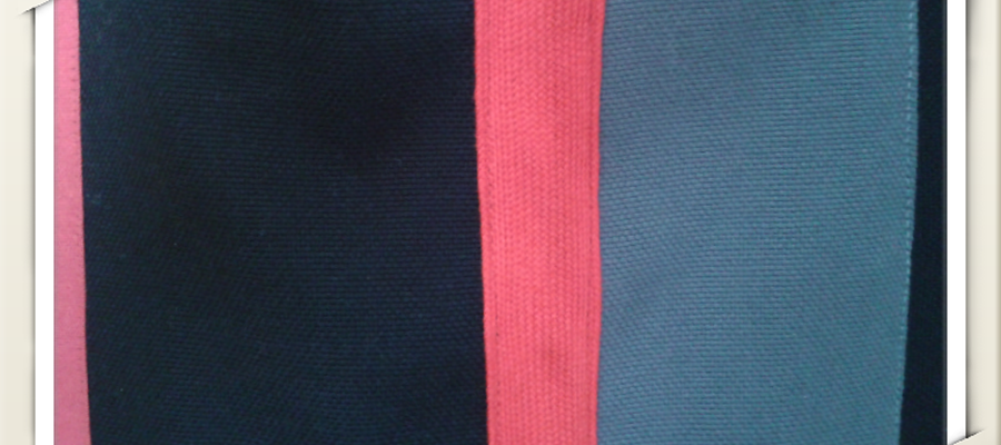 Loneta grisa eta beltza, oihal eta zinta gorriarekin. Tira beltzak eta grisak.