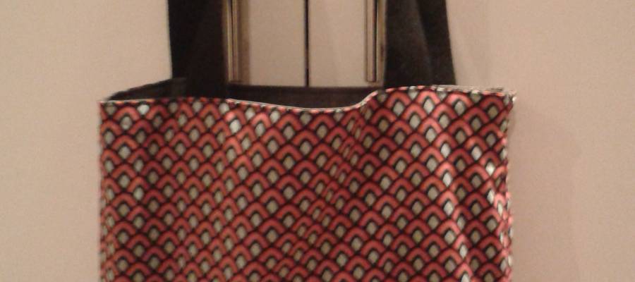 Kotoizko poltsa gris eta loreduna. Bi aldetara erabili daiteke.